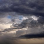 Nuvens cumulonimbus densas e escuras formam um céu carregado, indicando a aproximação de uma tempestade.